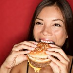 donna mangia hamburger cibo spazzatura