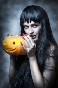 10832320-halloween-trucco-sexy-donna--strega-con-lunghi-capelli-neri-e-zucca-sorridere-e-guardare-al-colpo